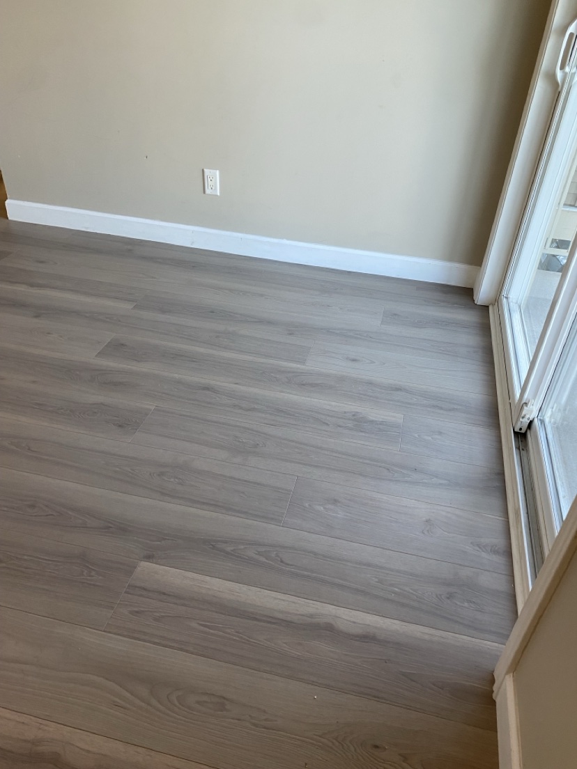 Empty room with a light grey-washed plank floor installed by Hearth & Plank