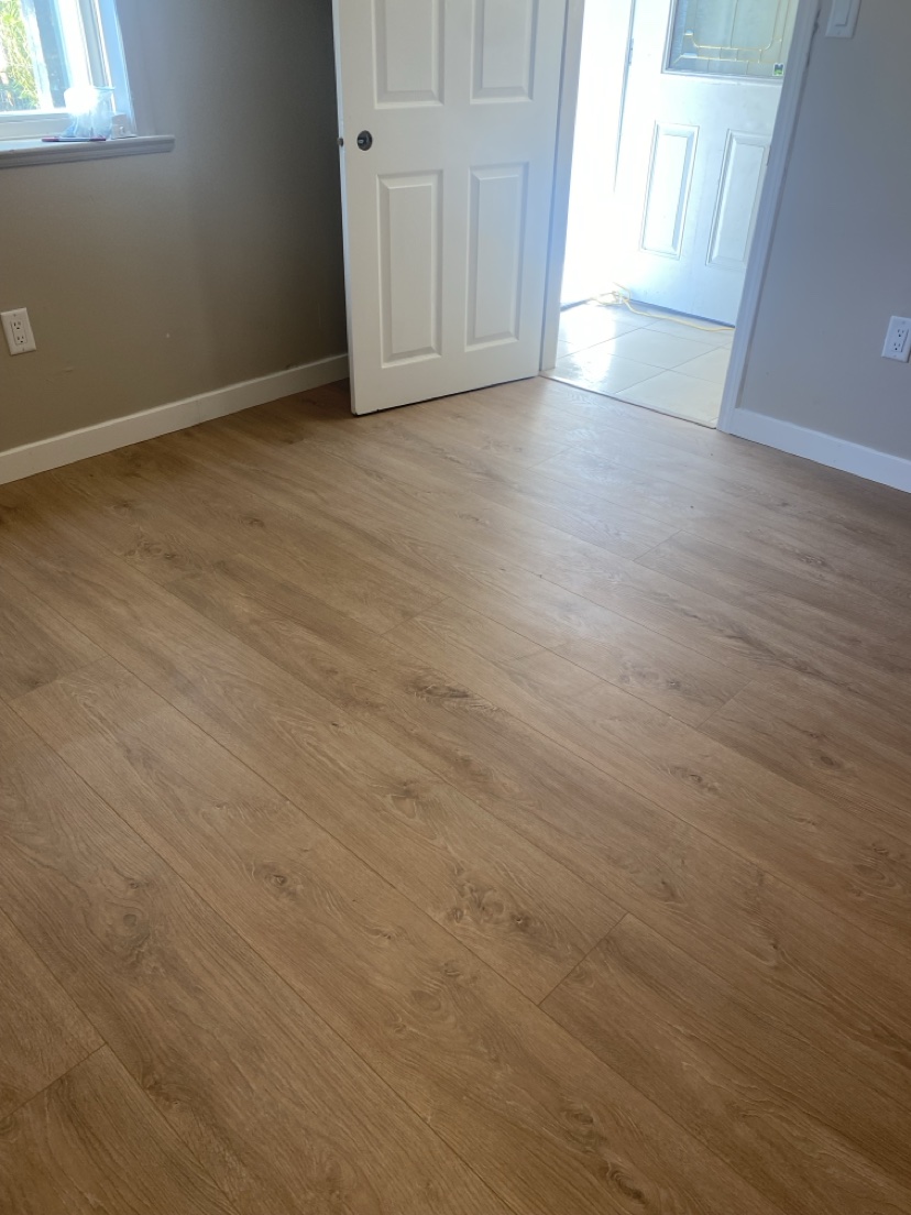 Room with a light natural plank floor and bright entry, installed by Hearth & Plank