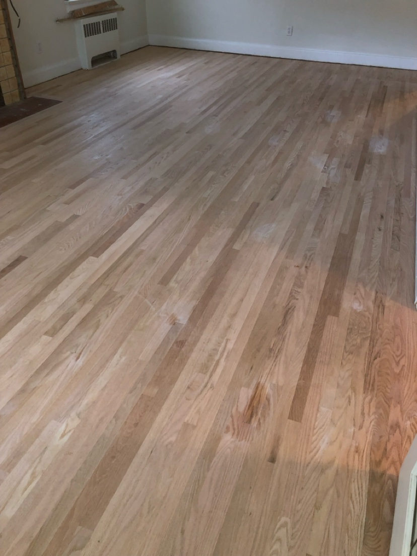 Room with a natural hardwood floor installed by Hearth & Plank
