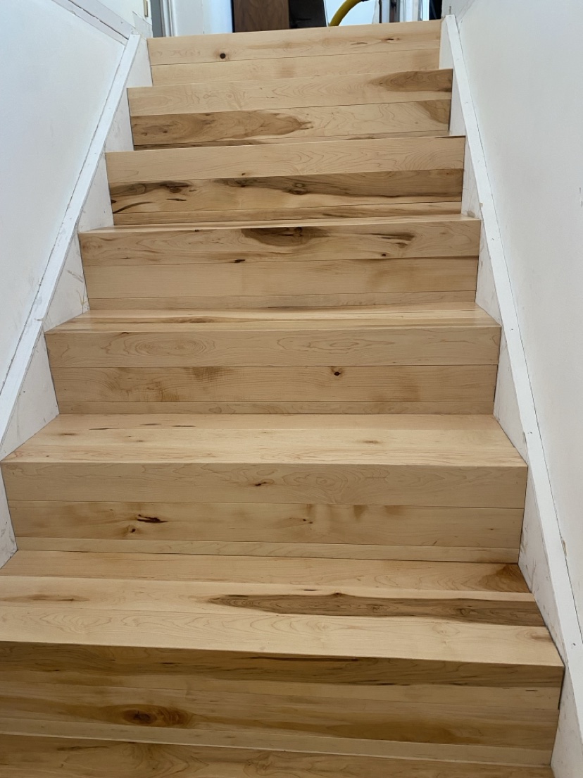 Natural wood staircase with new treads installed by Hearth & Plank
